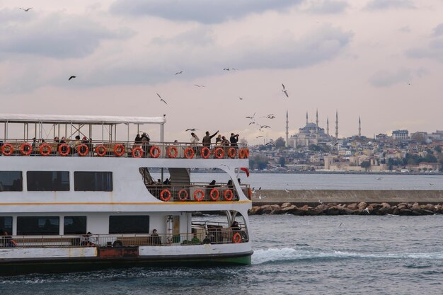 People throwing bagels at seagulls on a ferry in the Bosphorus