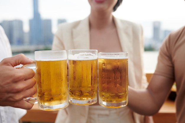 写真 ビールジョッキで乾杯する人