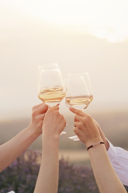 people toasting with wine glasses in front of a lavender field