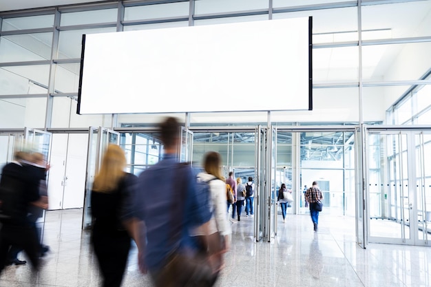 People on trade fair under advertising poster or banner
