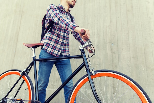사람, 여행, 관광, 레저 및 라이프스타일 - 도시 거리에서 고정 기어 자전거와 배낭을 든 젊은 힙스터 남자 가까이