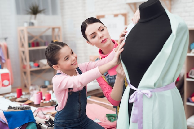 People trying on clothes on a mannequin.