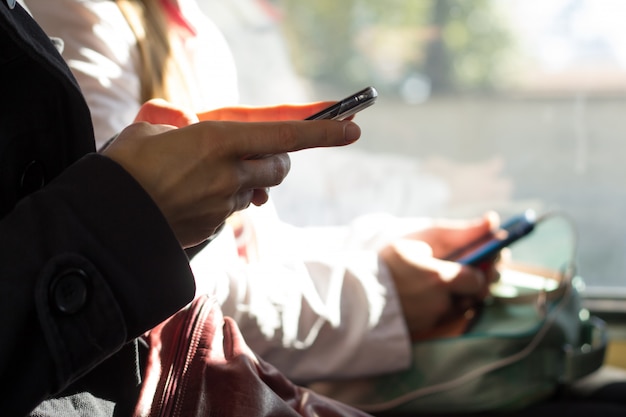 Foto le persone usano gli smartphone nei trasporti pubblici. primo piano del telefono cellulare in mano.