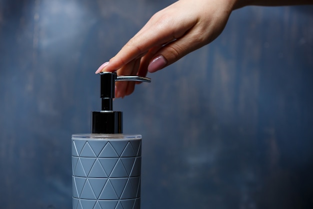 People use the soap dispenser with a metal cap of gray on a gray table