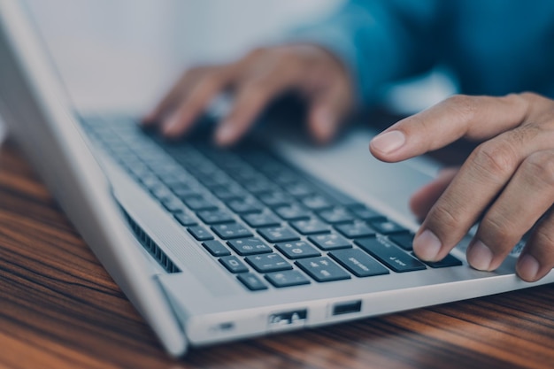 People using computer Side view of male hands typing on laptop keyboard