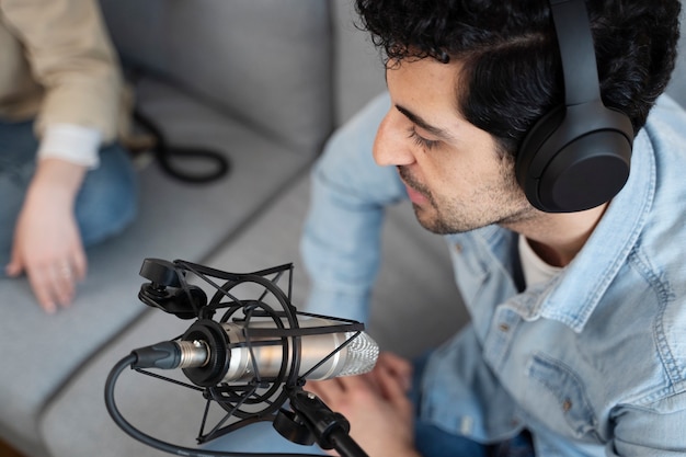 Foto persone che usano i microfoni durante una sessione di podcast