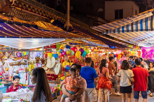 Люди посещают и покупают красочные традиционные фонари, висящие во время фестиваля середины осени