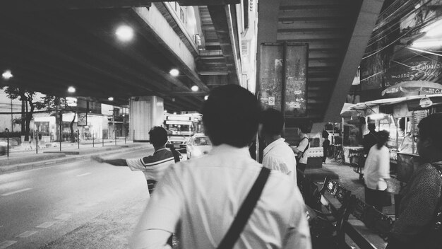 Photo people waiting at bus stop under bridge