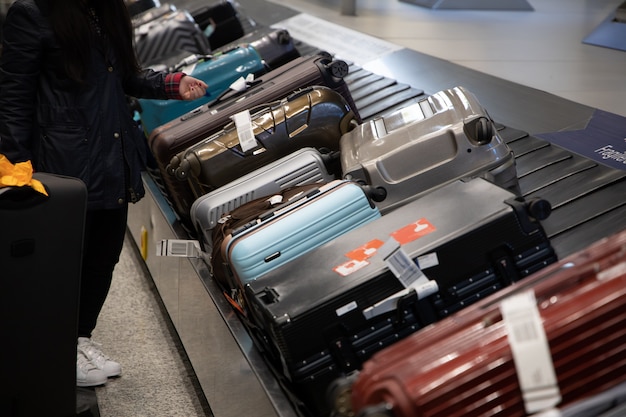 空港でコンベアベルトに荷物を待っている人