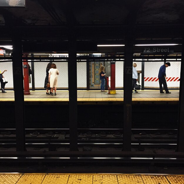 Foto gente in attesa alla stazione della metropolitana.