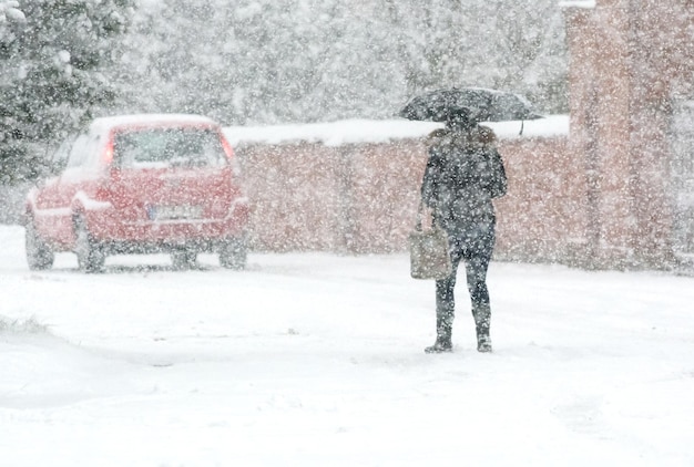 人々は雪に覆われた通りを歩きます