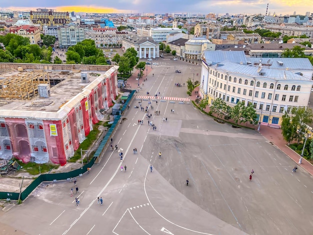 Люди гуляют по площади с высоты птичьего полета Вид на городскую площадь сверху Люди гуляют по площади красивого города Реставрируемое здание Киев Украина 05032023