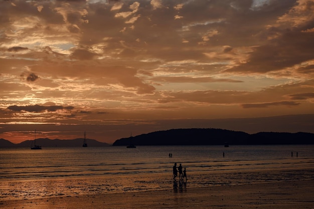 People walking at the beach on beautiful summer sunset
