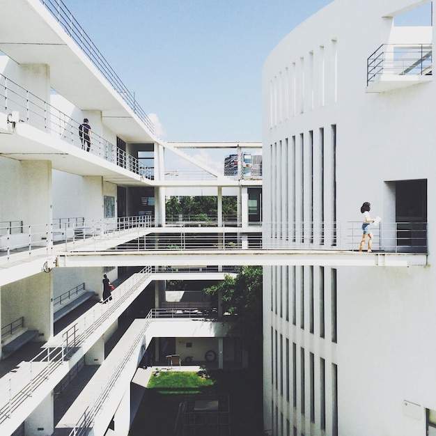 Photo people walking on building in university against clear sky