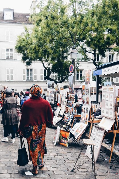 街で絵画のそばを歩く人々