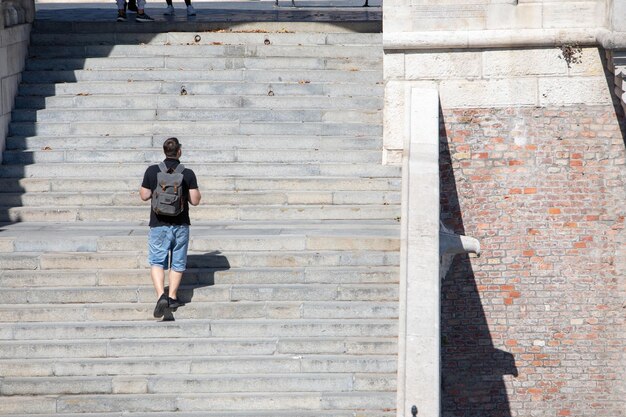 People walking by stone stairs with backpack