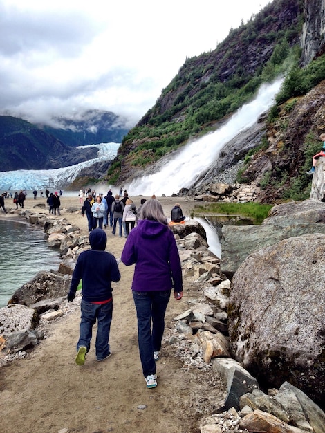 Foto gente che cammina vicino alla cascata