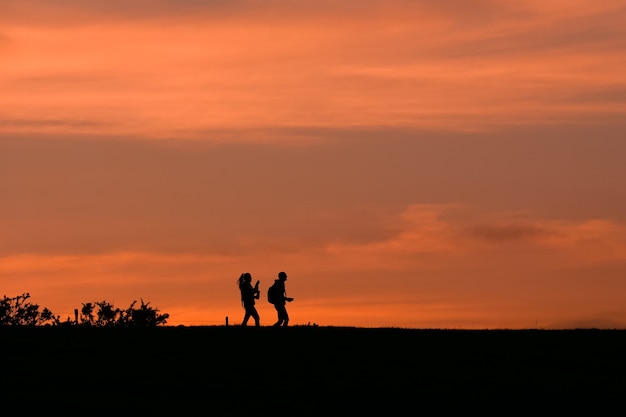 美しい夕日の田舎を歩く人々