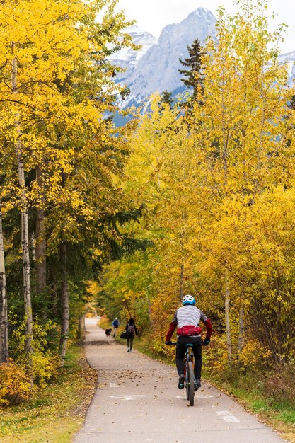Foto gente che cammina e va in bicicletta sul spur line trail in autunno canmore alberta canada