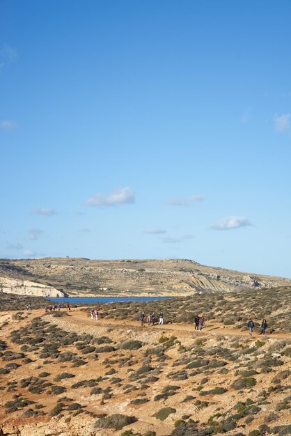 People walking at desert against sky