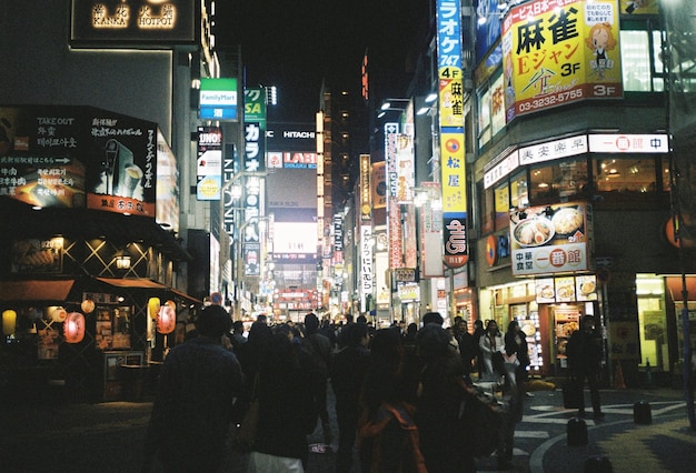 Foto persone che camminano su una strada illuminata a tokyo