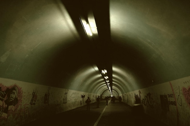 Foto gente che cammina in un tunnel illuminato