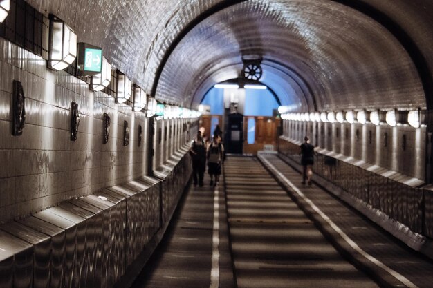 Photo people walking in illuminated tunnel