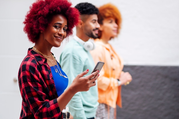 people walking looking at the mobile phone and looking at camera