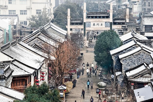 사진 도시 에서 눈 으로 인 집 들 사이 에서 보행자 도로 를 고 있는 사람 들