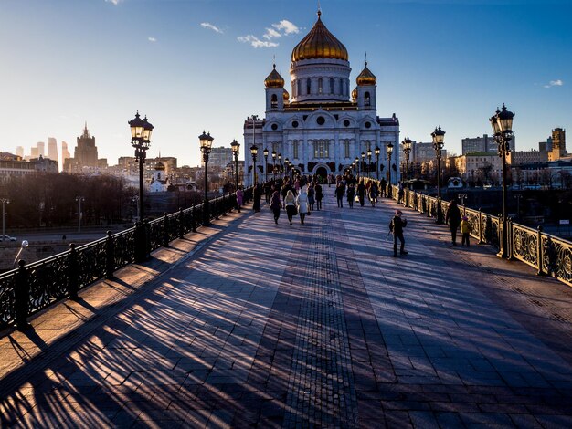 Фото Люди идут по патриаршескому мосту, ведущему к храму христа спасителя.