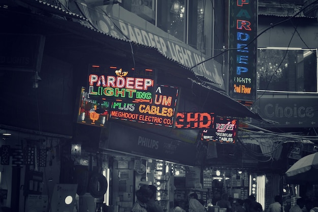 people walking on road along neon signboards