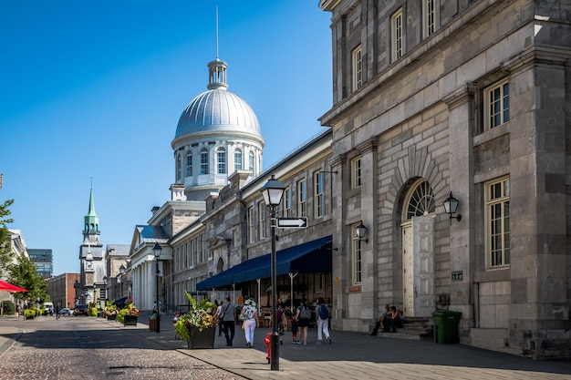 Foto persone che camminano sulla strada tra gli edifici della città