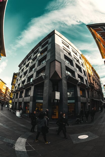 Foto persone che camminano sulla strada tra gli edifici della città