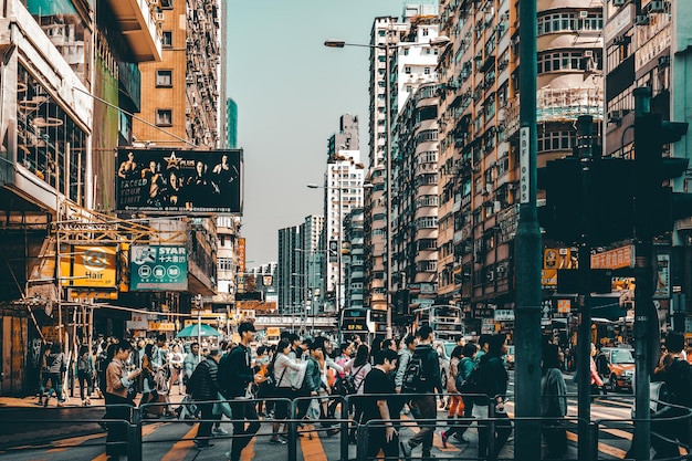 people walking on road amidst buildings in city