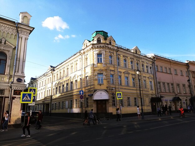 People walking on street against buildings in city