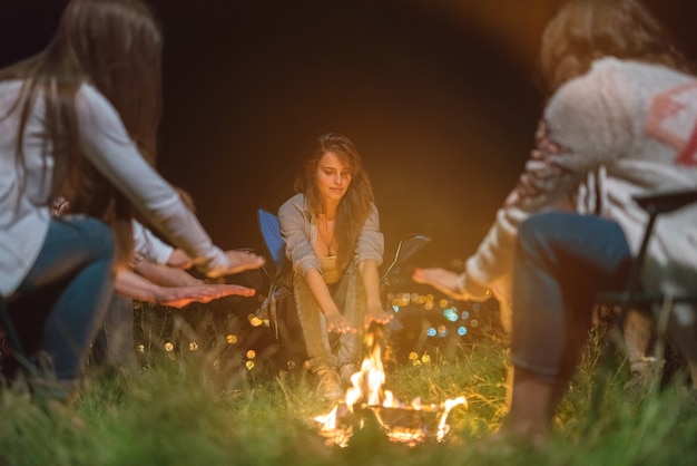 The people warming hands near the bonfire. evening night time