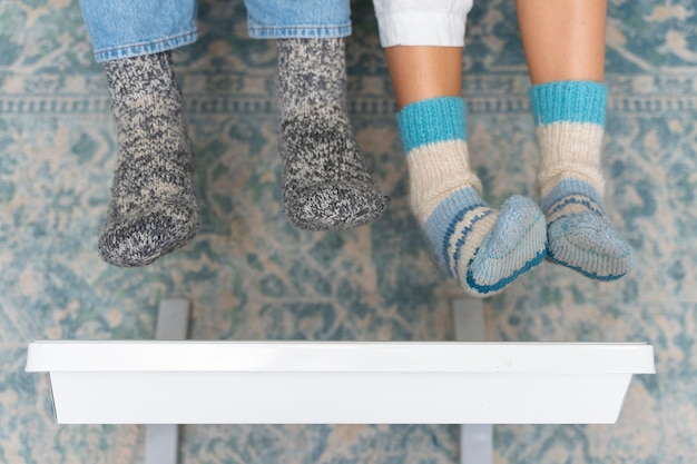 Photo people warming up their feet by the heater