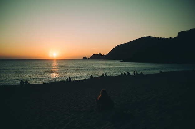 people watching sunset on the beach