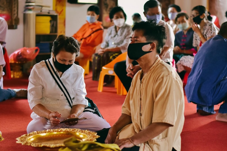 Photo people wearing mask sitting at temple