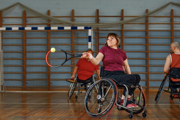 Люди в инвалидной коляске играют в теннис на корте Wheel Chair Tennis