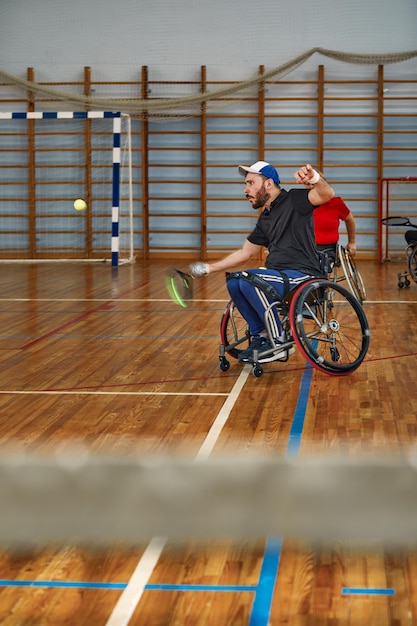 Foto persone in sedia a rotelle che giocano a tennis sul campo tennis in sedia a rotelle