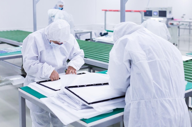 Foto la gente in costumi d'isolamento bianchi che lavorano in laboratorio