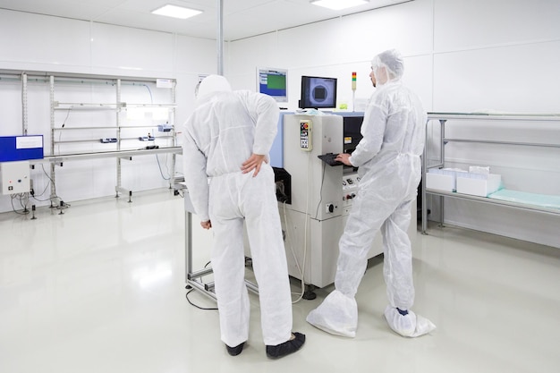 People in white isolating costumes working in laboratory