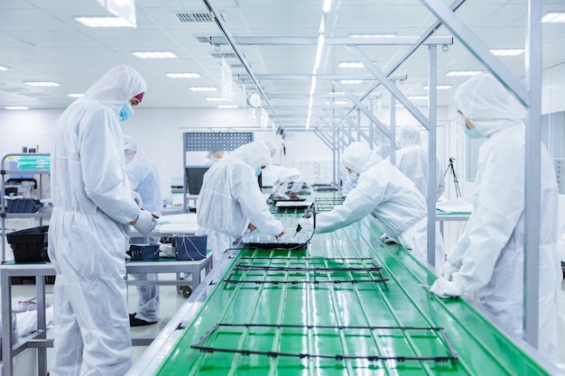 People in white isolating costumes working in laboratory