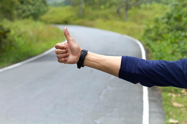 写真 道路でヒッチハイクを見せる人