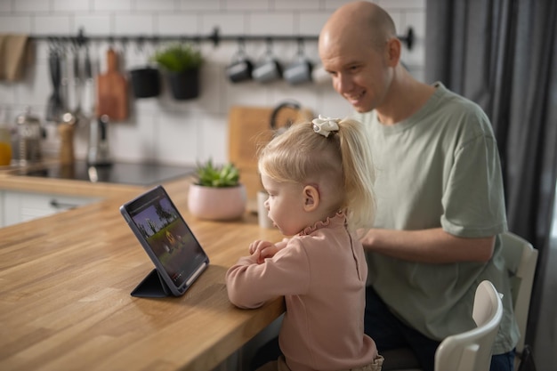 People with cochlear implant system Kid study to hear with her father learning with video on tablet Installation cochlear implant on child girl ear for restores hearing