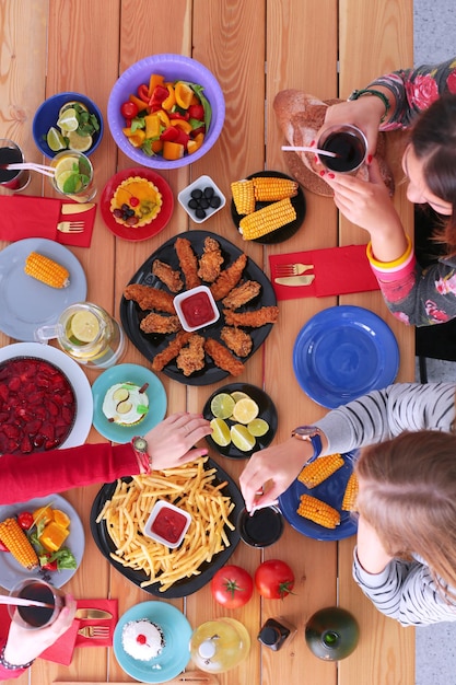 People with drinks while sitting at the dining table