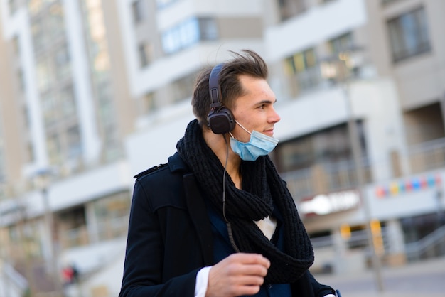 People with face mask. Concept with copy space. Portrait of adult man in quarantine of flu. Photo on the street in the city