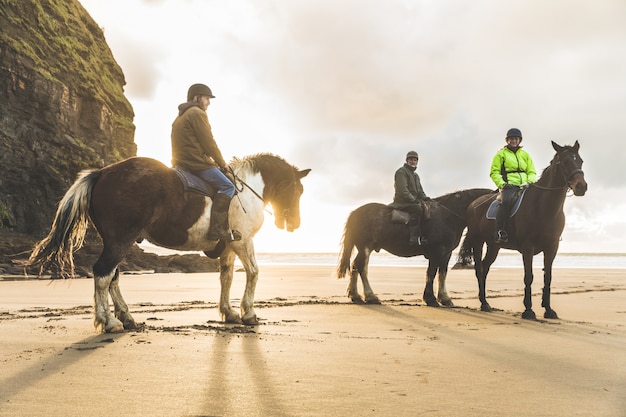 Люди с лошадьми на пляже в пасмурный день