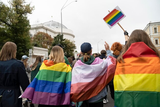 LGBT 깃발을 든 사람들이 행진하고 있습니다.